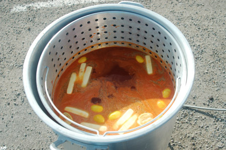 Adding butter, lemons, oranges, and seasonings to the crawfish boil.
